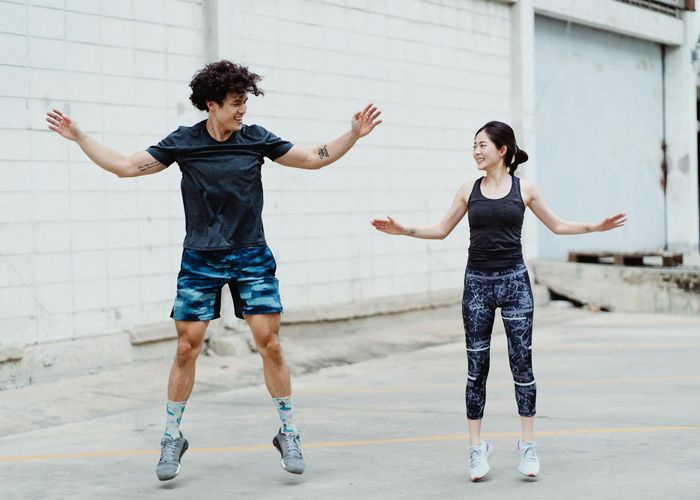 Energetic woman jumping in a training hall showing vitality and strength.